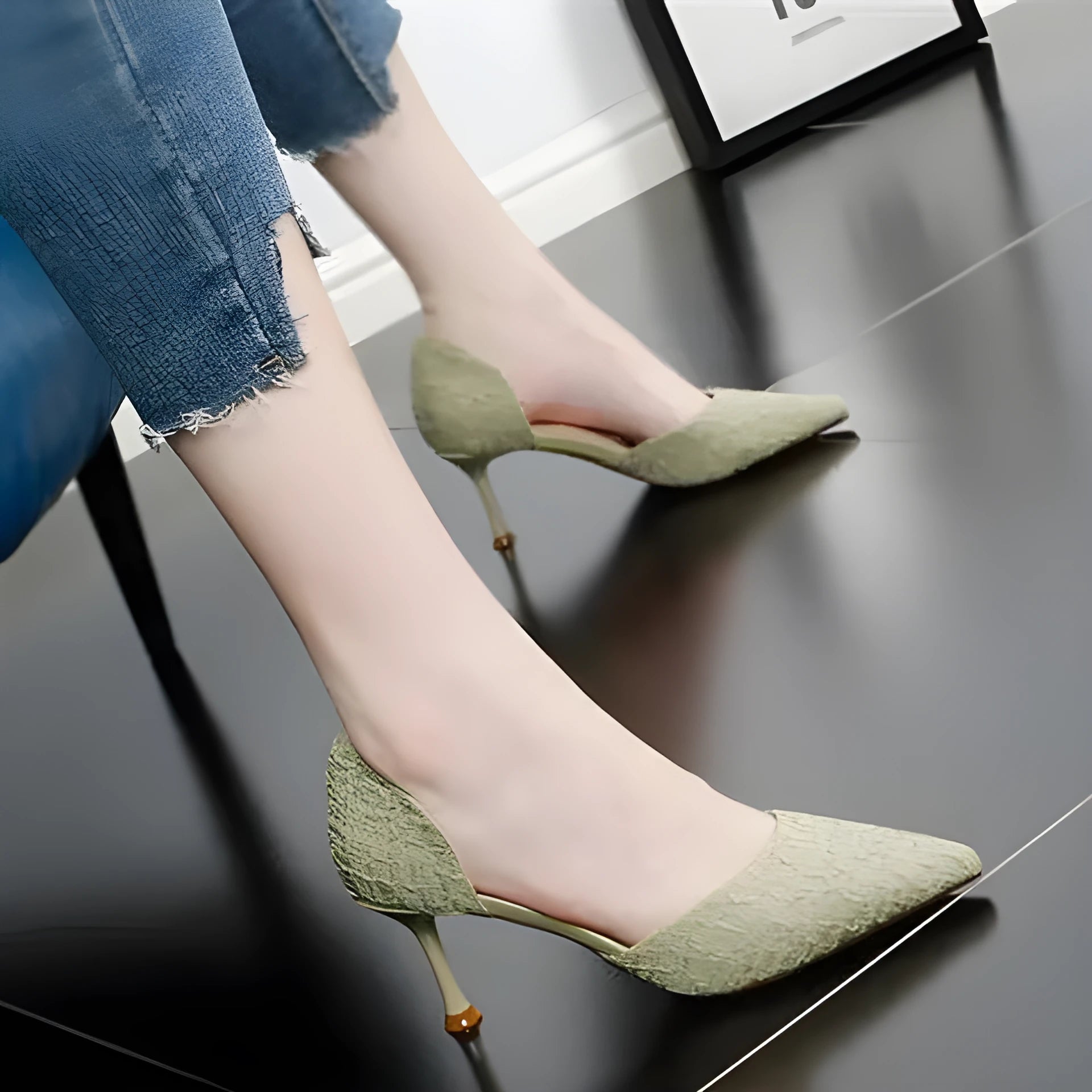 Women's black pointed stiletto high heels with a thin heel on a plain background.