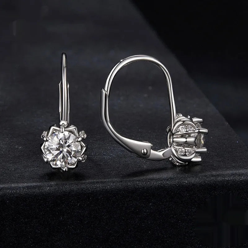 Sterling silver flower bud ear clip with white gold plating and a central moissanite stone.