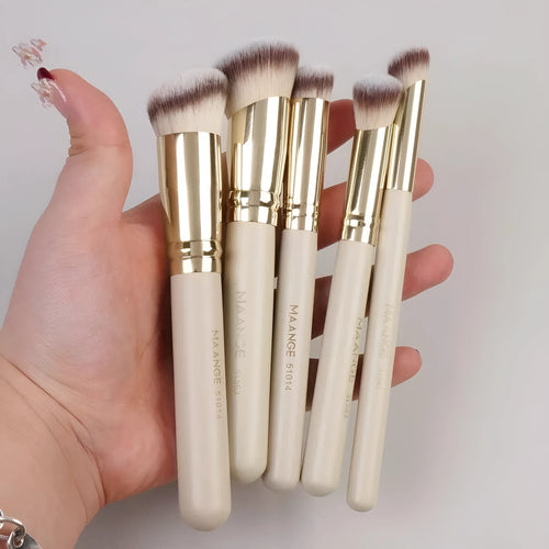 Angled apricot blusher brush and four other synthetic makeup brushes on a white surface.