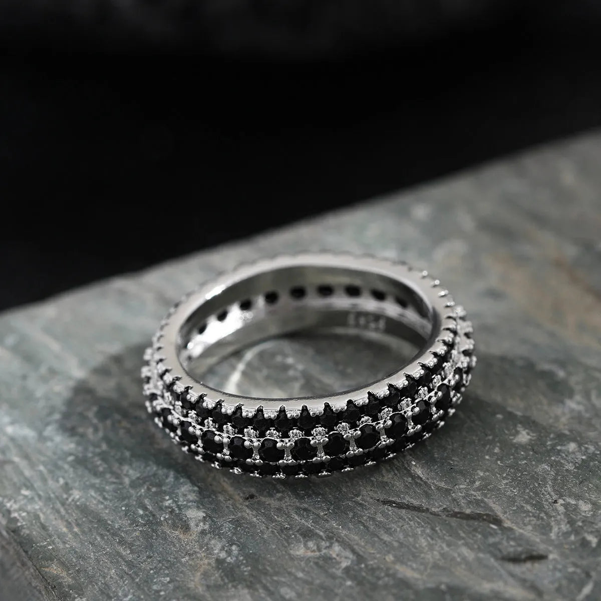 Geometric triangle design zircon inlay ring in copper, shown on a finger.