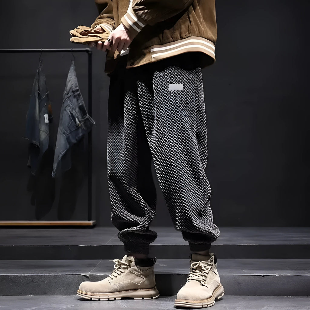 Men's grey ankle-tied straight-leg sweatpants laid flat, showing the tapered cut and tie detail.