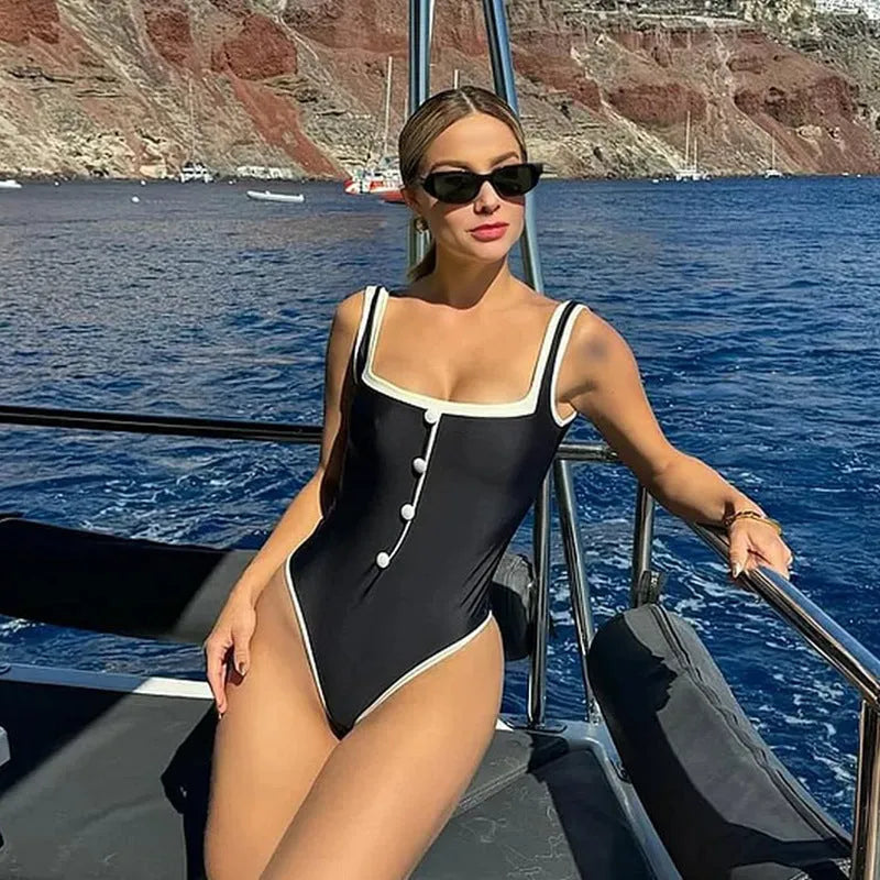 Black and white colour matching one-piece swimsuit with classic style belly coverage, backless design