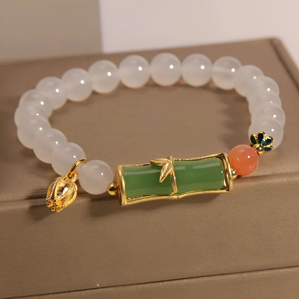 Women's white agate and jade bamboo joint beaded bracelet on a wrist.