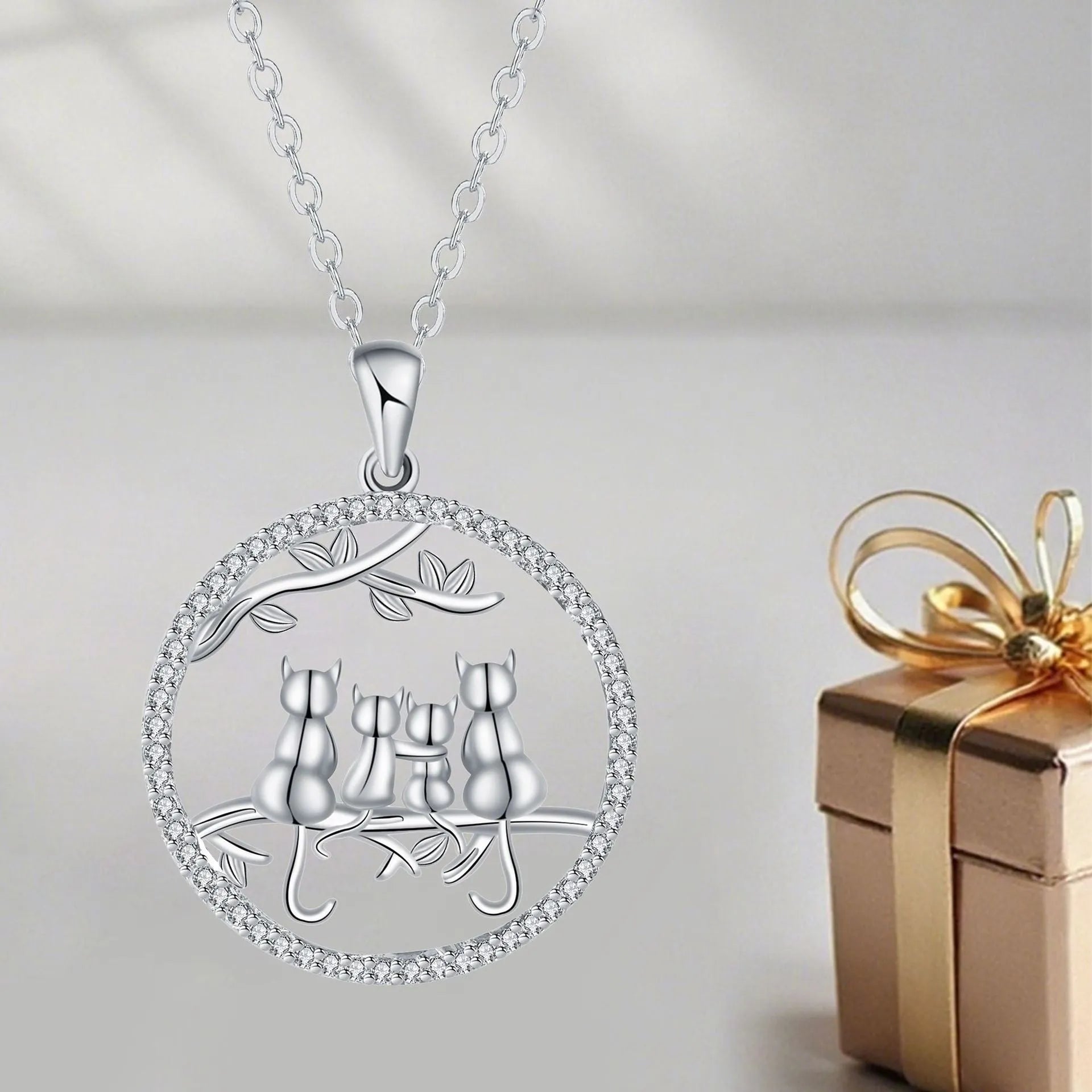 Copper necklace with a four-cat pendant on a textured cross chain, electroplated finish.