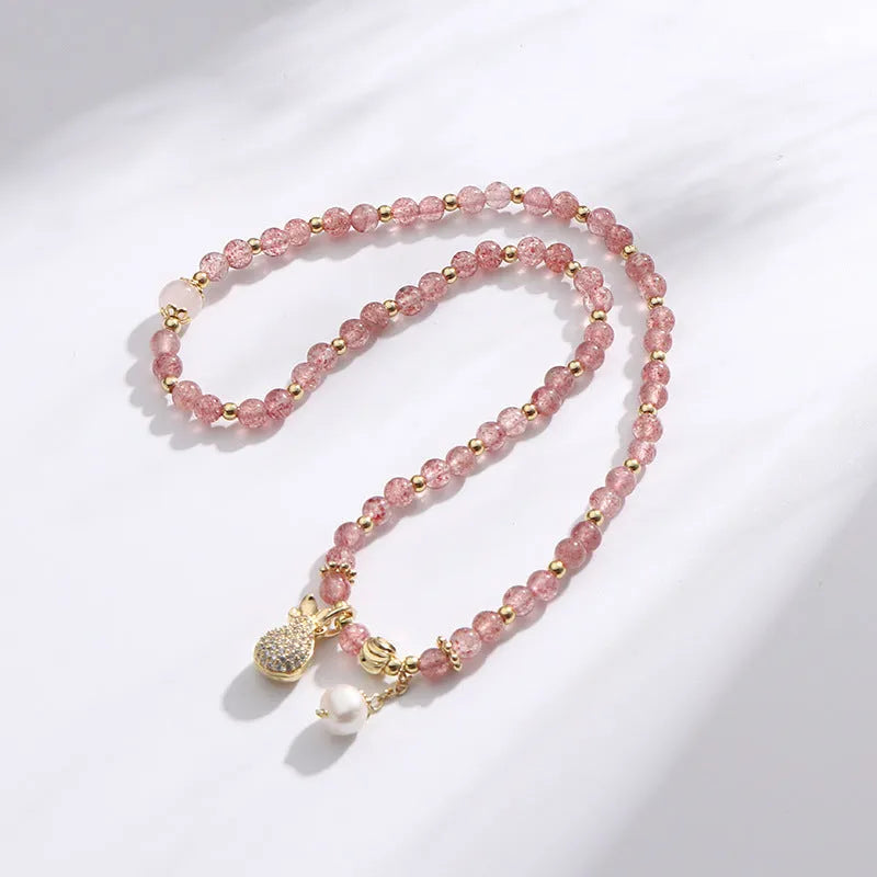 Geometric strawberry quartz crystal bracelet for women on a wrist.