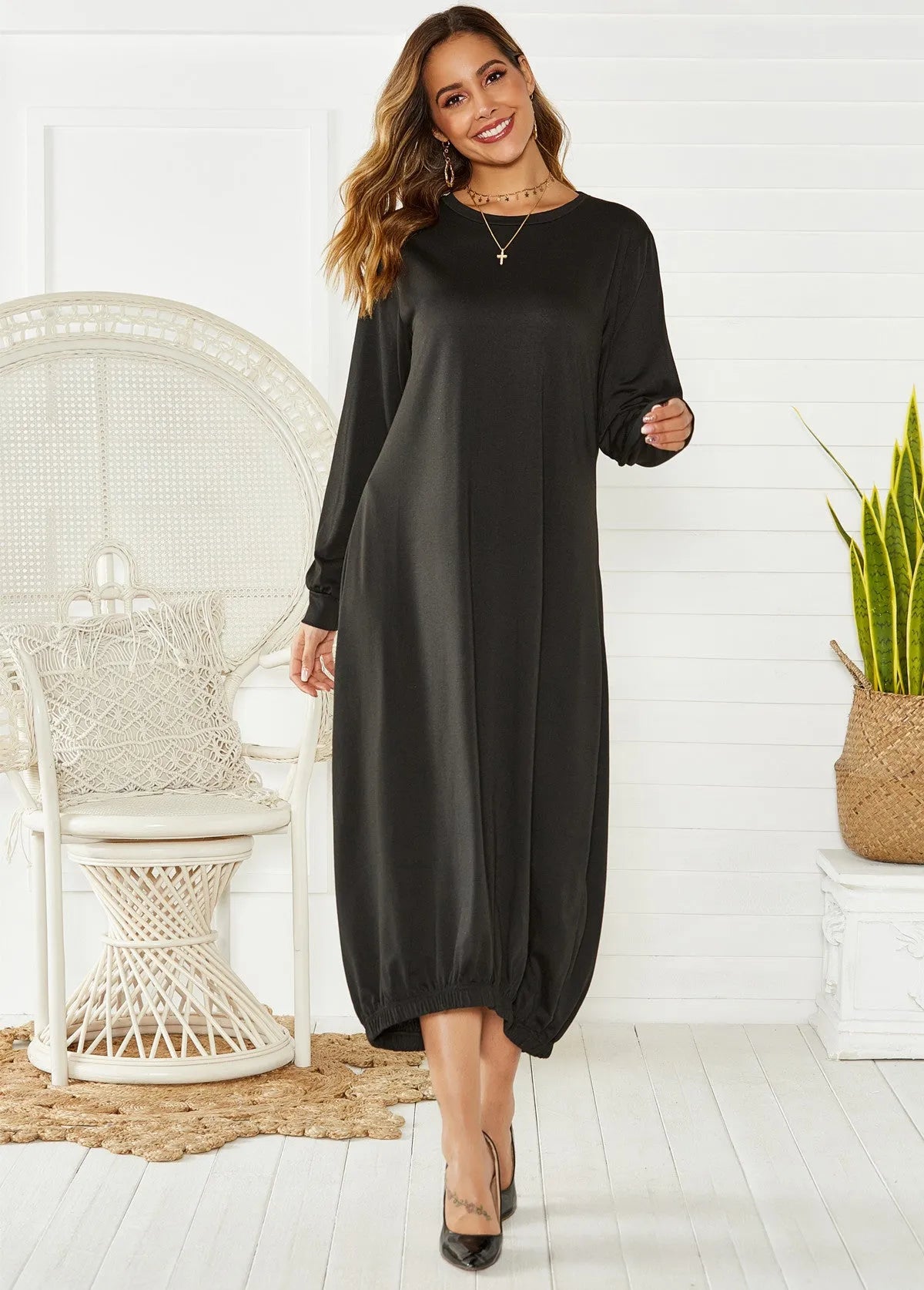 Loose-fitting black lantern dress with a crew neck and lace-up front detail on a mannequin.