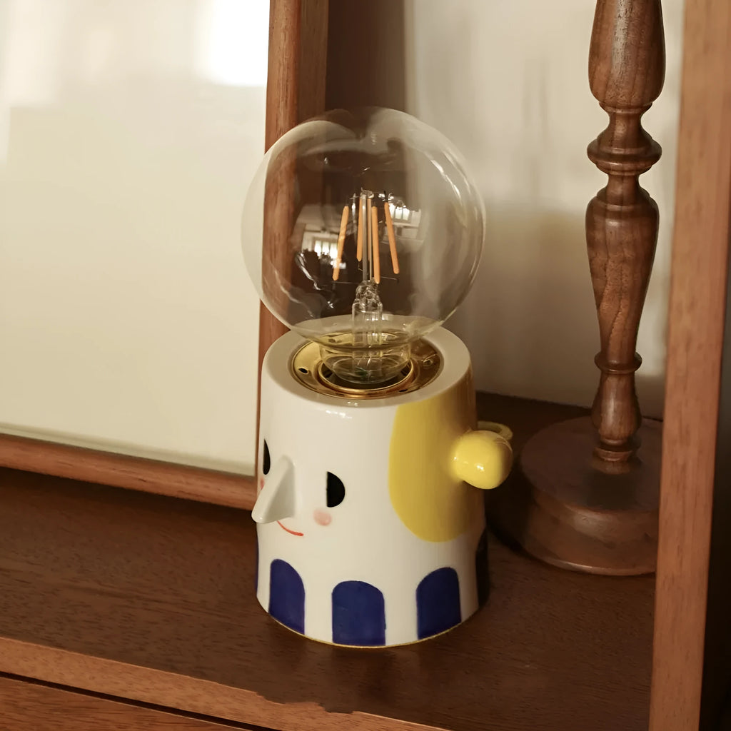 Handmade ceramic table lamp with ball headlight design on a bedside table