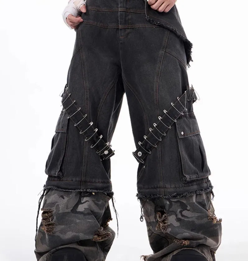 Grey men's jeans with camouflage pattern and spliced construction, showing pin and ribbon details.