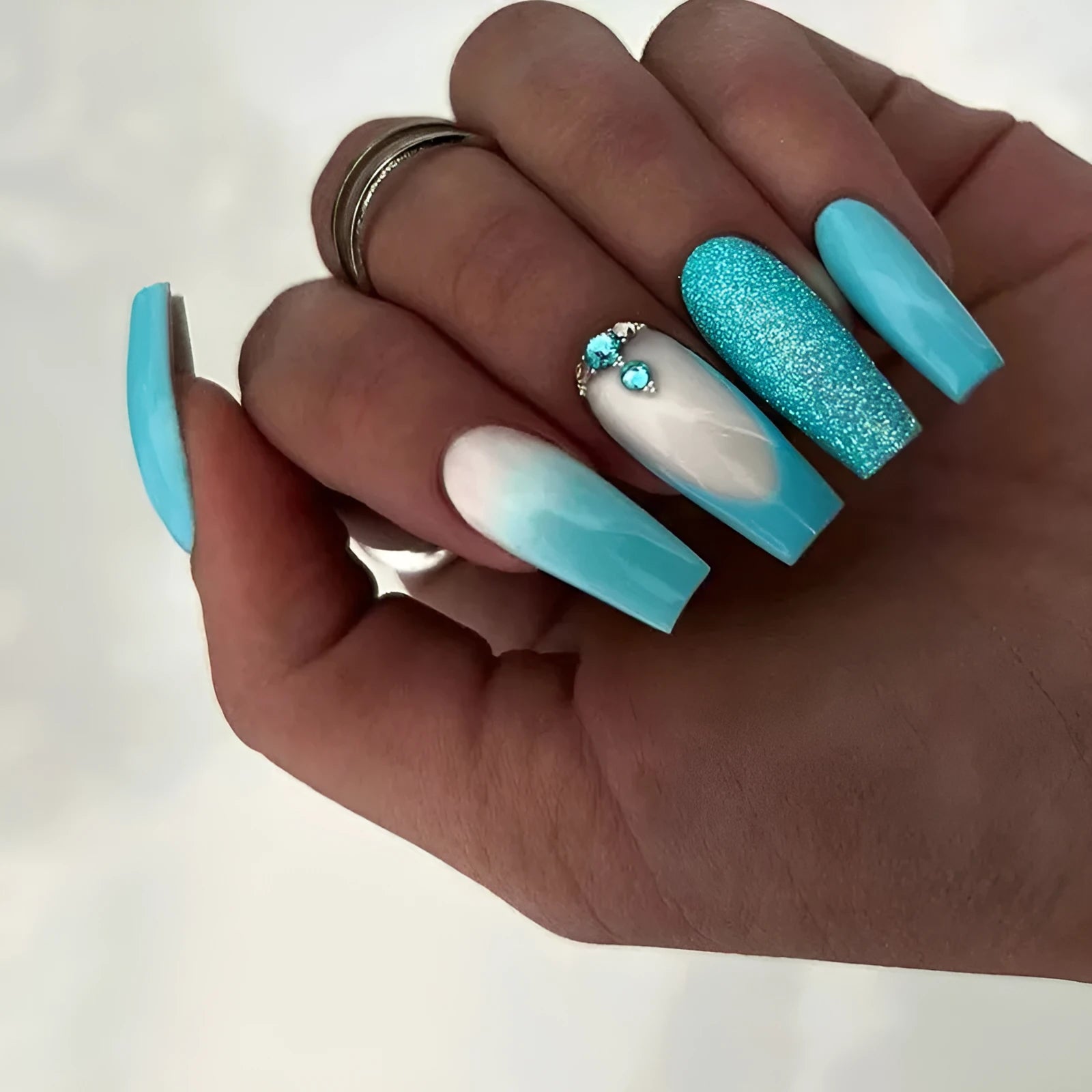 Solid colour long ballet false nails with blue diamond glitter accents and adhesive glue
