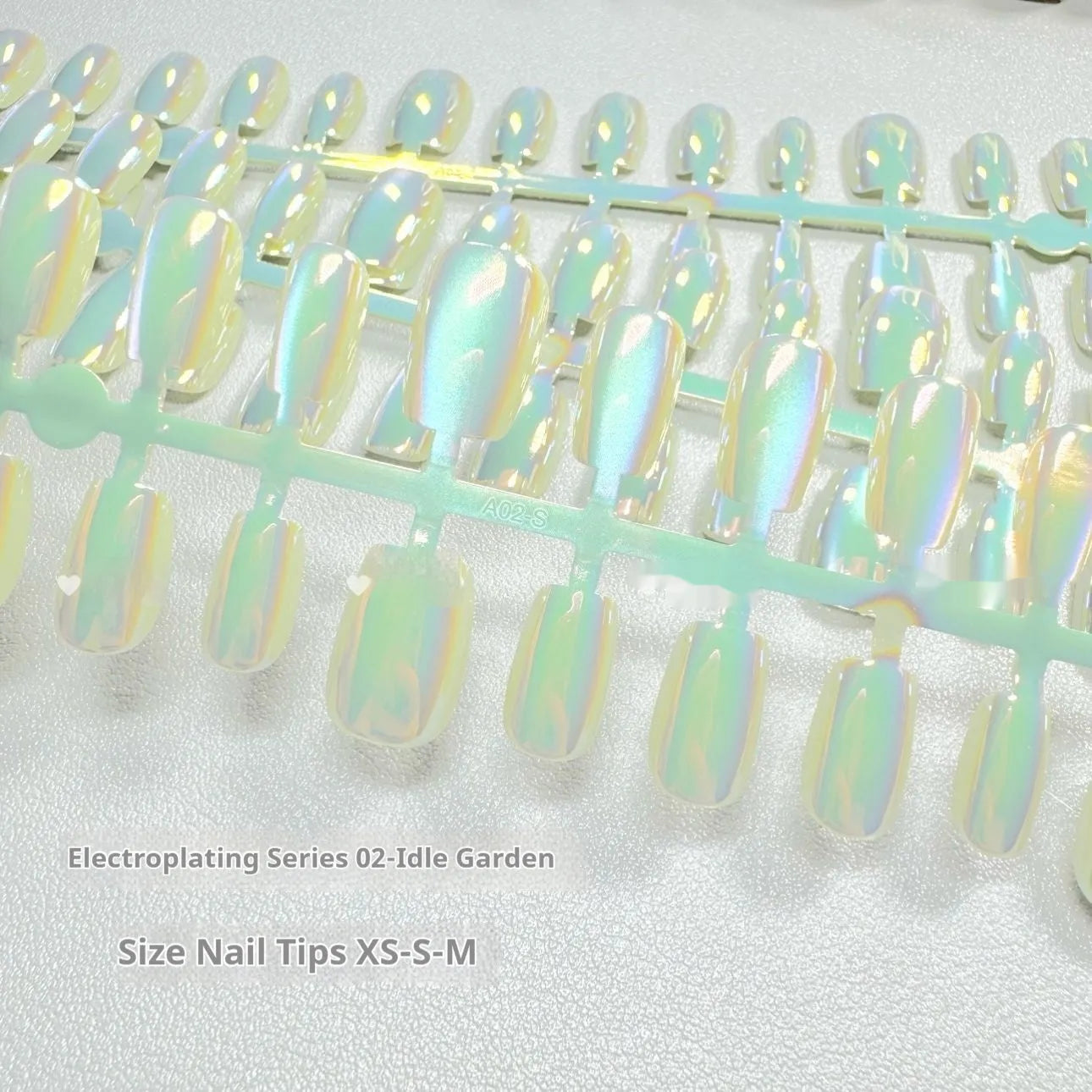 Electroplated Cat's Eye artificial nail art set in short ladder lengths XS, S, and M on display.