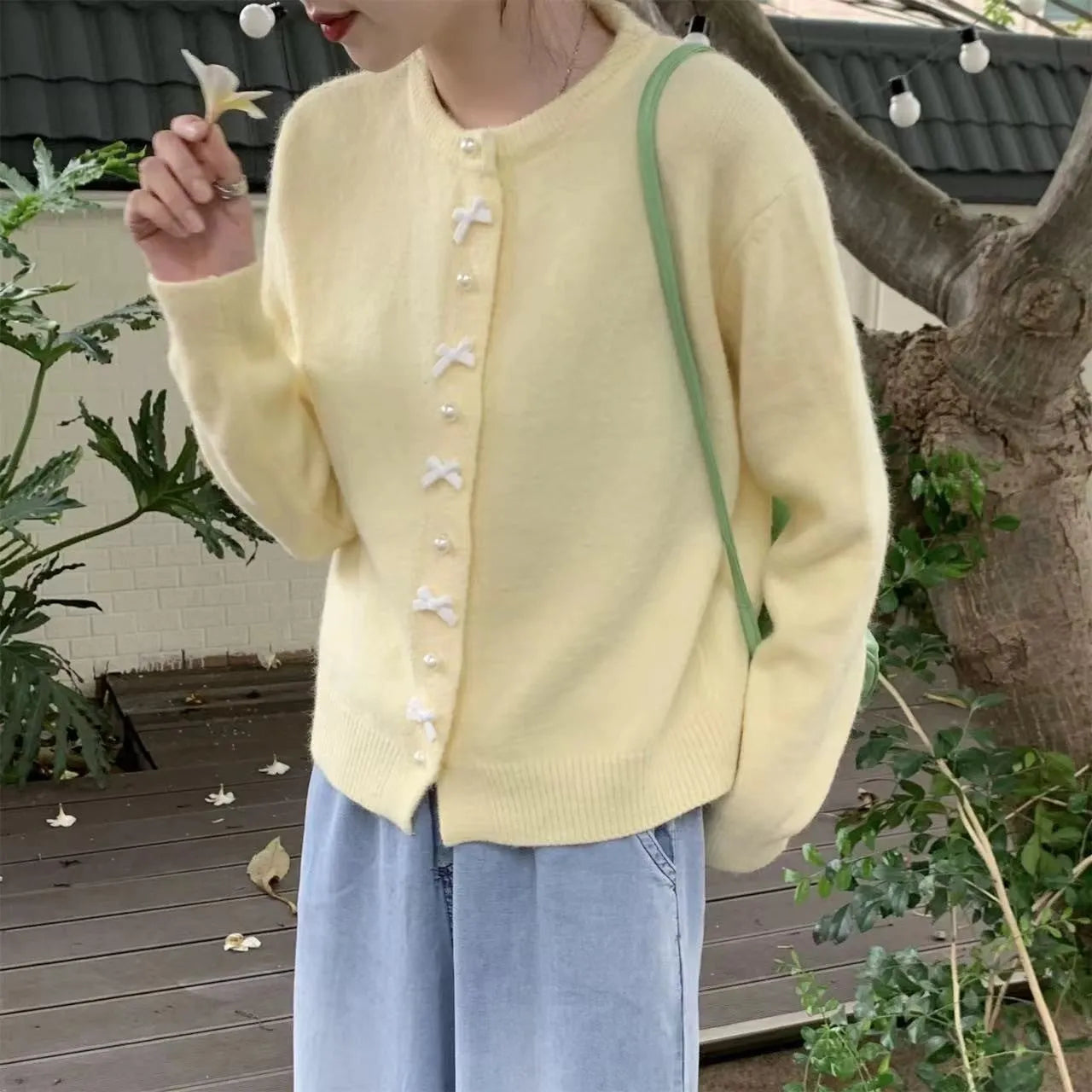 Women's solid colour cardigan with bow and pearl buttons, cashmere acrylic blend, shown in multiple colour options.