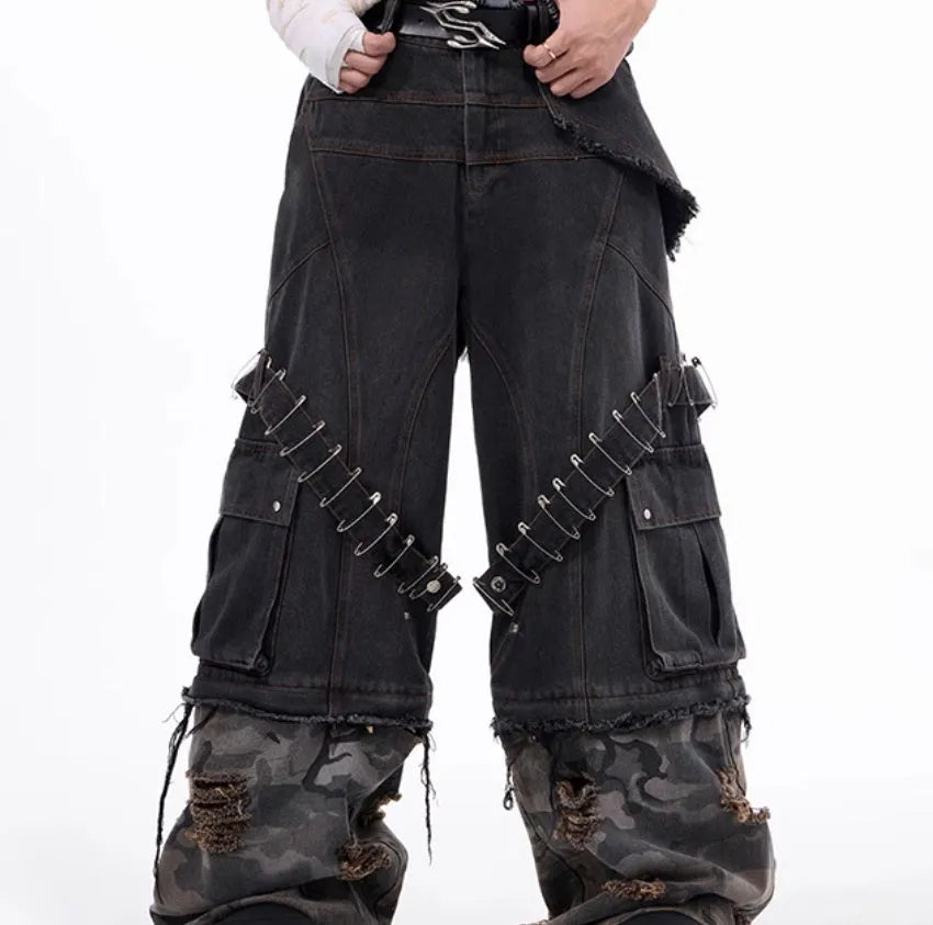 Grey men's jeans with camouflage pattern and spliced construction, showing pin and ribbon details.