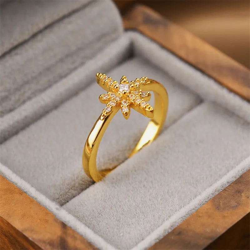 Gold geometric open ring for women on a grey background.
