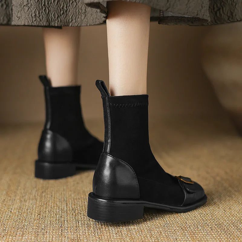 Women's black low heel lace-up Martin ankle boots with belt buckle detail on a white background.