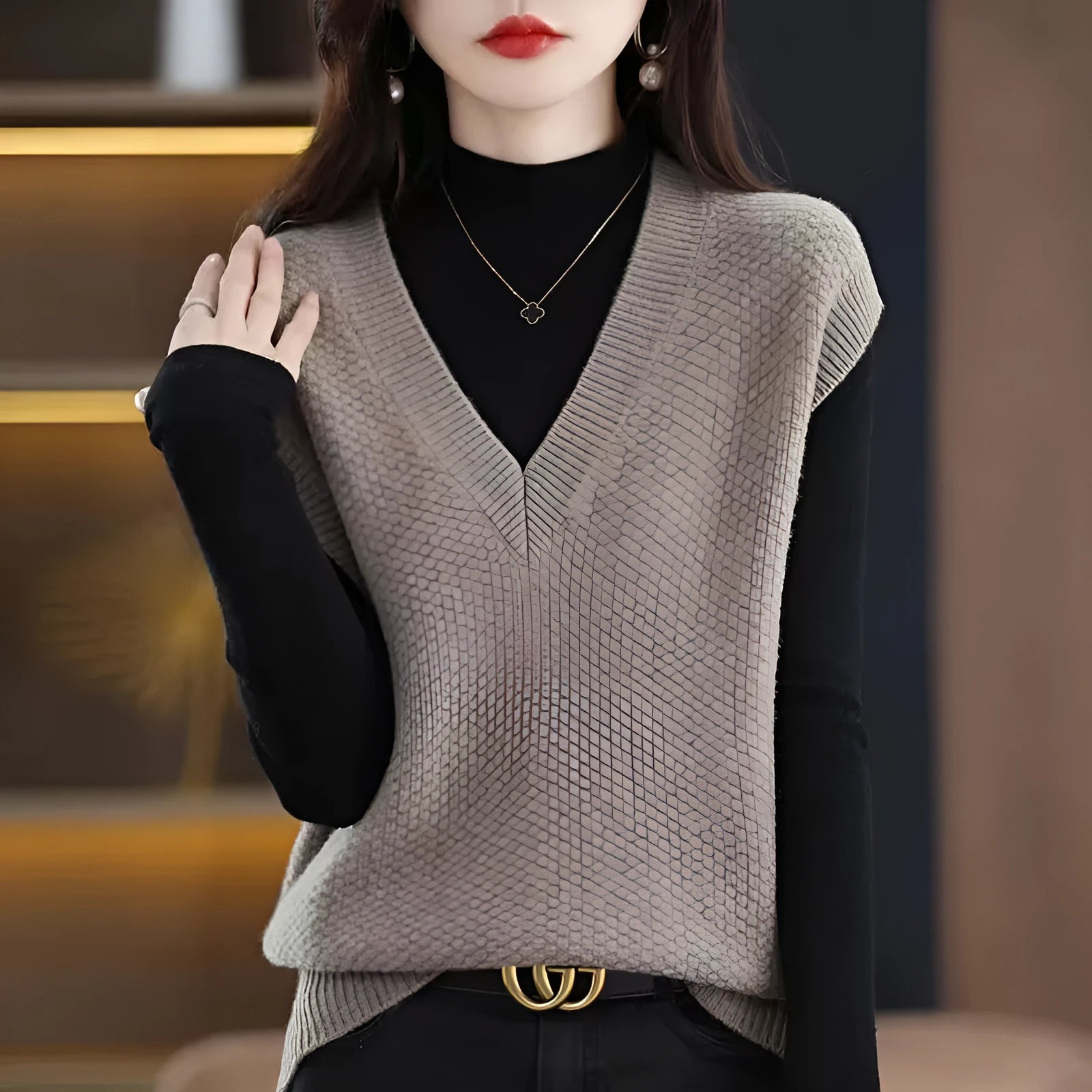 Women's creamy-white V-neck sleeveless knitted vest with a textured 3D pattern on a hanger.