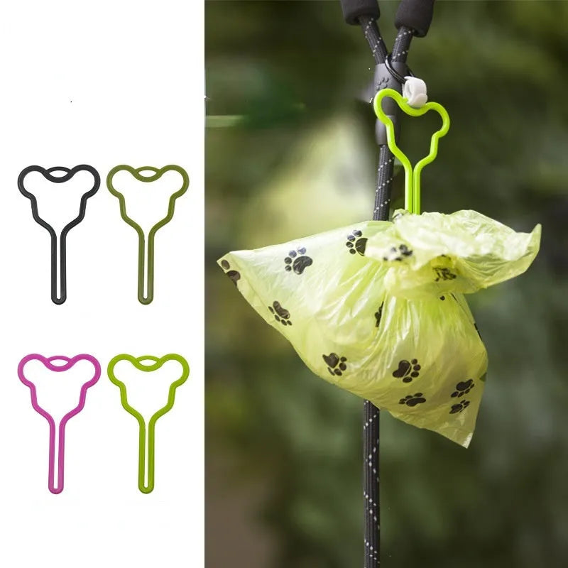 A coloured hands-free dog poop bag holder with a fixed clip and velcro strap attached to a dog leash.