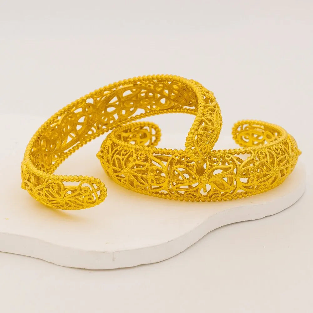 Gold wedding bracelet with hollow flower and cherry pattern on a white background