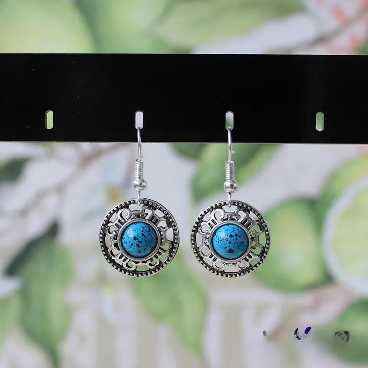 Handmade geometric flower disk earrings in Tibetan silver and turquoise with ethnic Miao design.