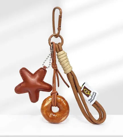 Handmade soda bread handbag pendant ornament with brown carrying strap on a bag.