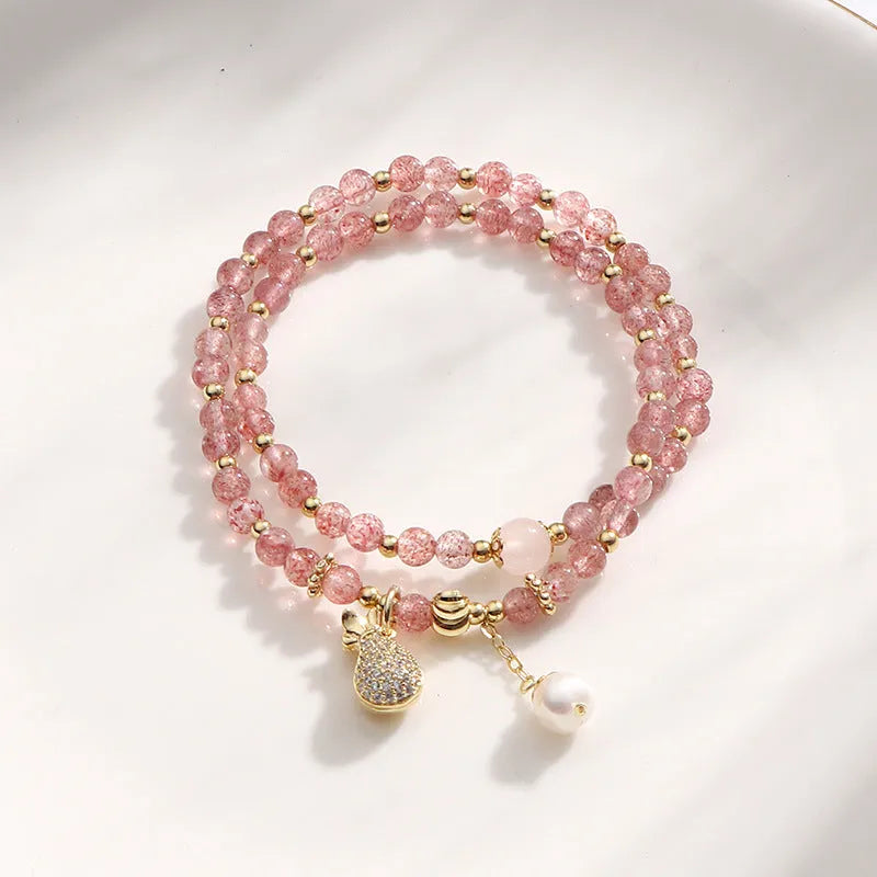 Geometric strawberry quartz crystal bracelet for women on a wrist.
