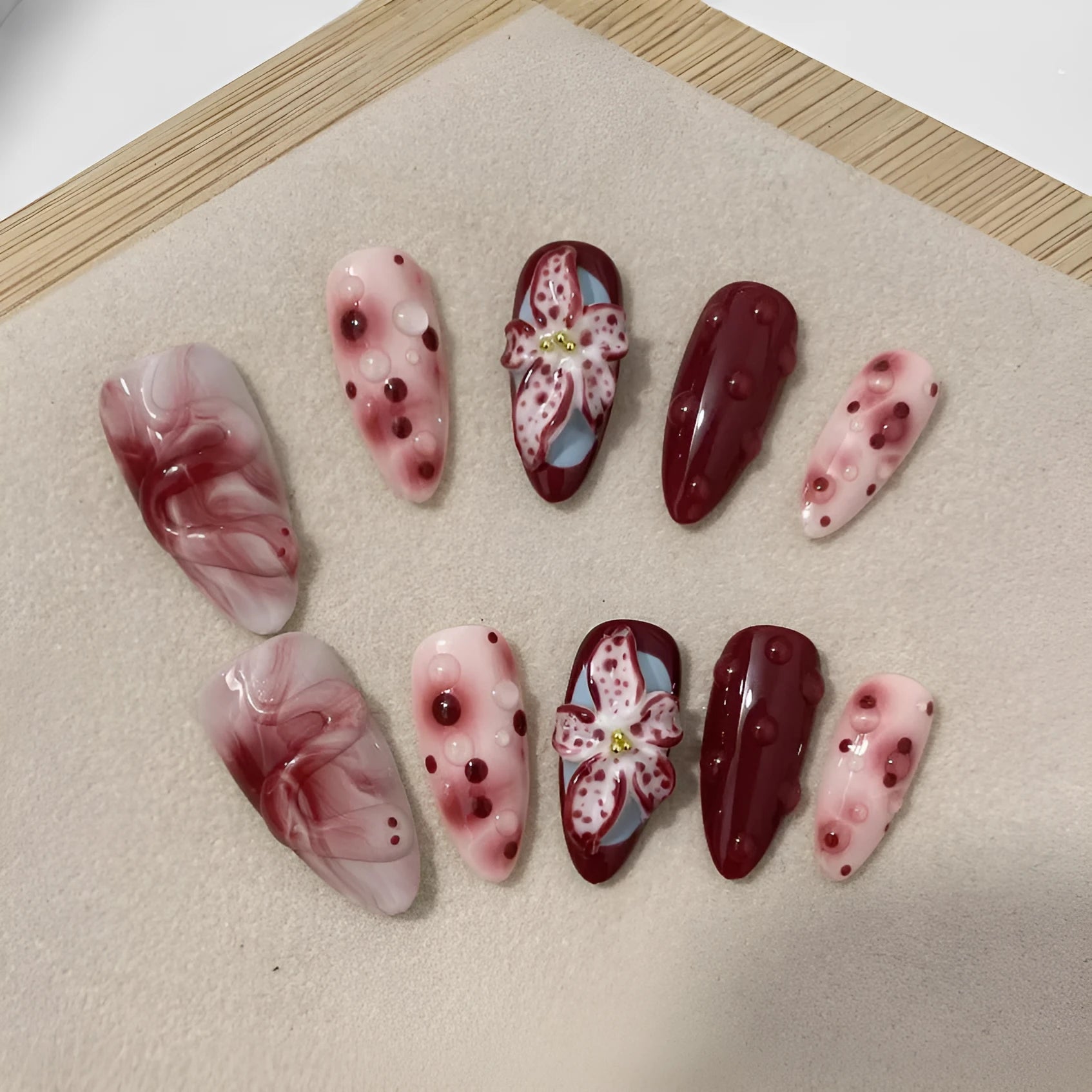 Hand-painted 3D carved manicure nails in almond colour and mid-length almond shape, showing rose and leopard print designs.