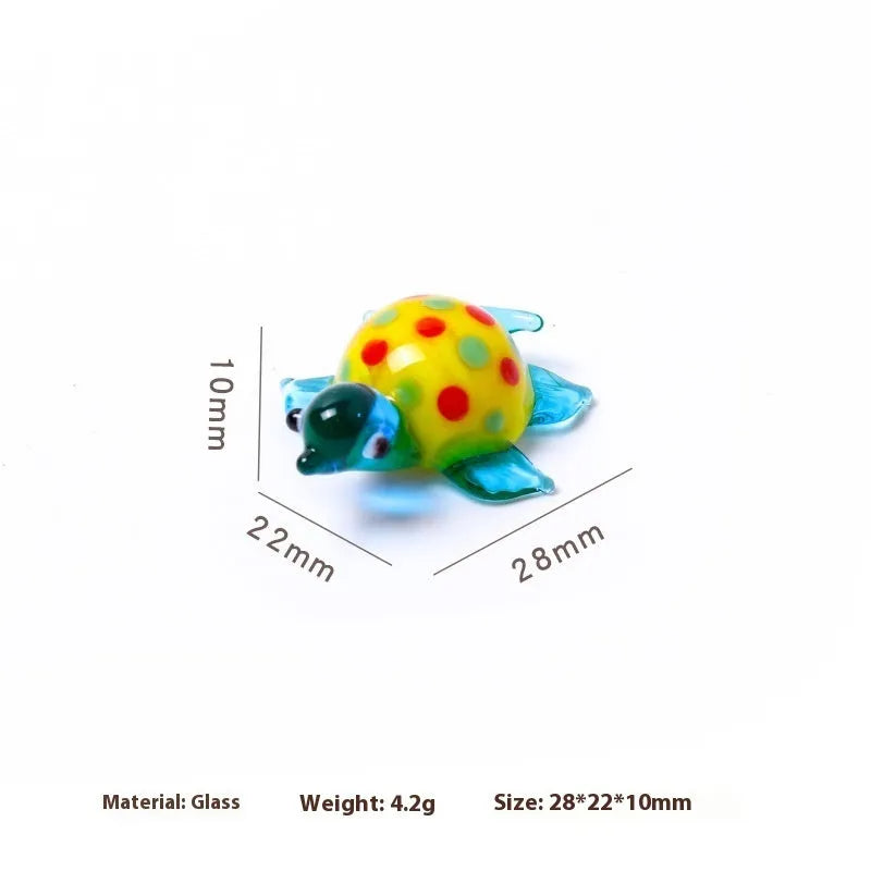 Geometric glass turtle ornament with a blue head and blue shell on a wooden desktop.