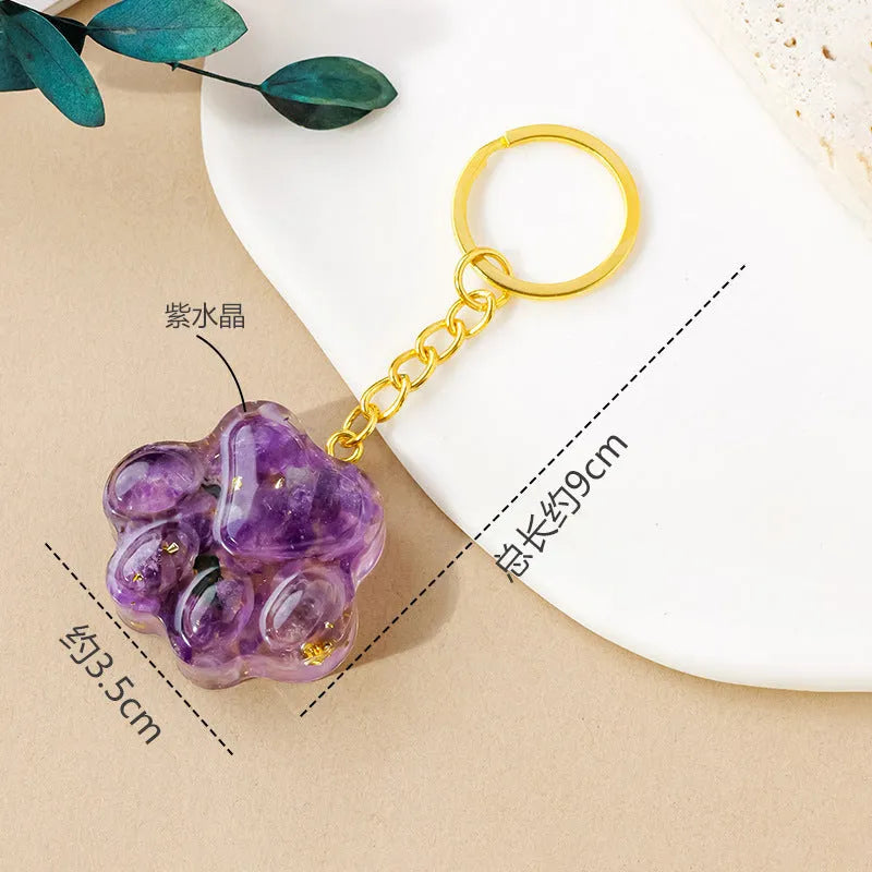Small natural crystal cat's paw keychain pendant on a metal ring.
