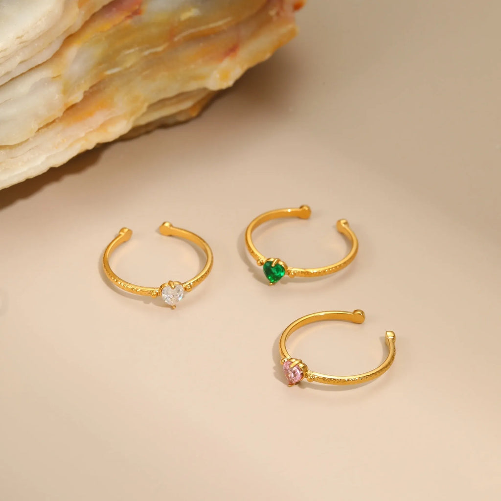 Open-ended stainless steel ring with a geometric heart shape and inlaid green zircon stone.