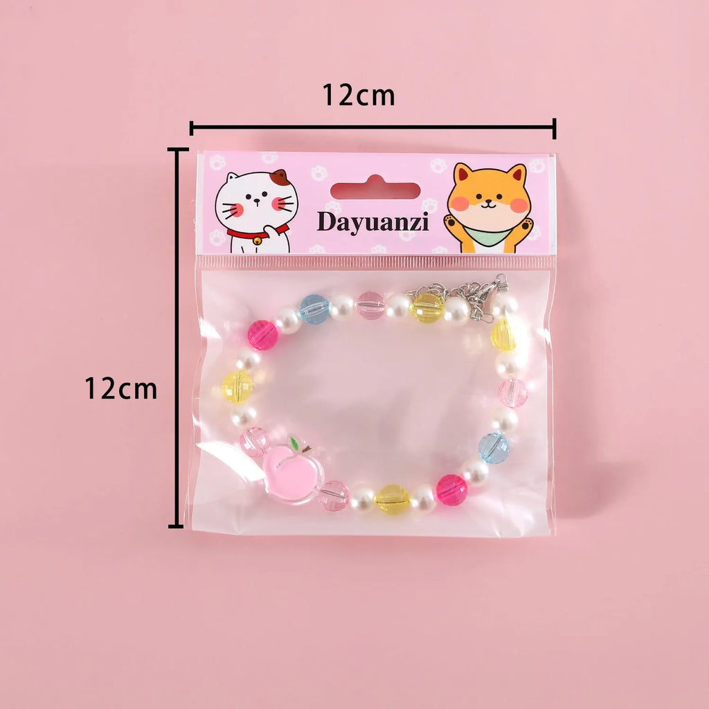 Colourful plastic bead cat necklace in small flower, rainbow, or peach design on adjustable cord.