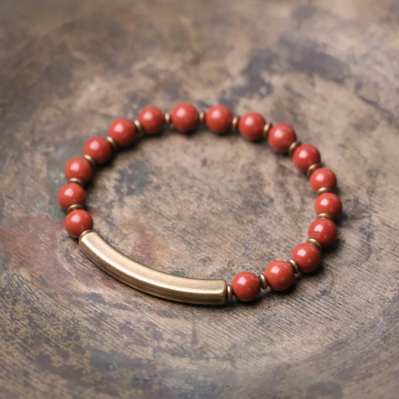 Layered retro ethnic bracelet with natural stone beads and antique brass details on a wrist.