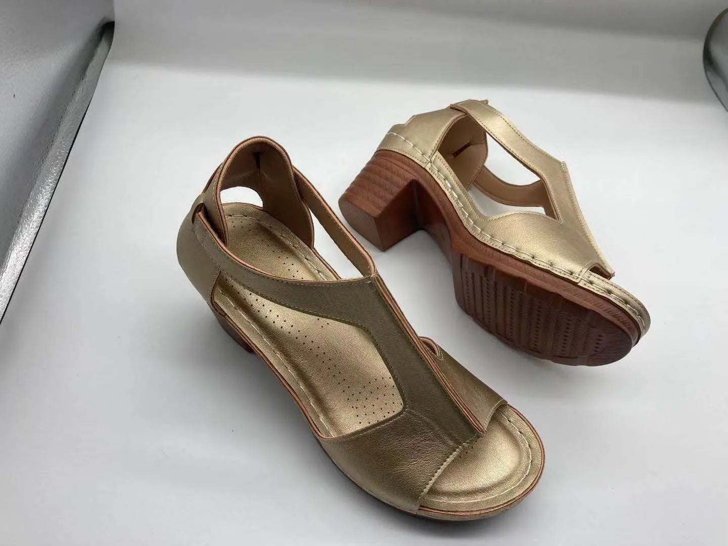 Women's peep toe wedge sandals with buckle detail, low heel, on a white background.