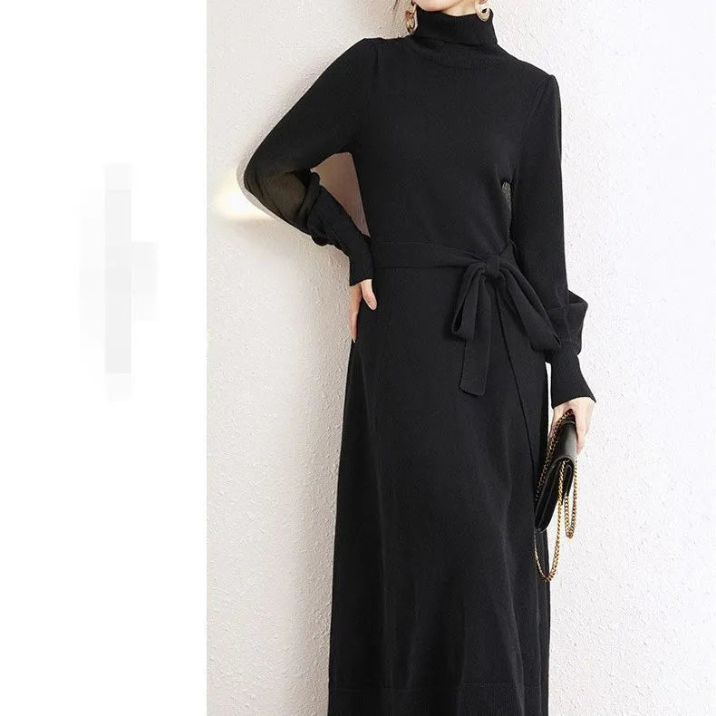 A rose red turtleneck knit dress with long sleeves, an elastic waist, and a loose mid-length skirt on a hanger.