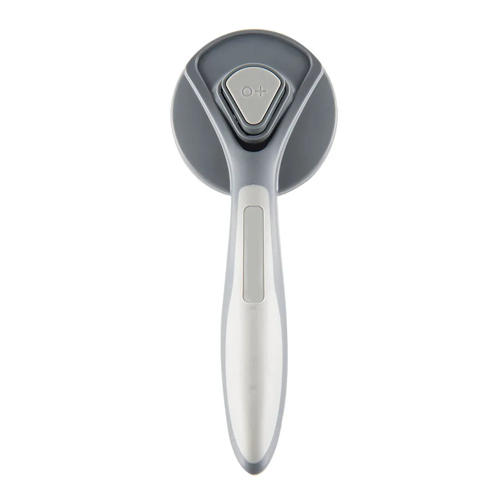 Grey self-cleaning slicker brush for grooming cats and dogs on a wooden table.