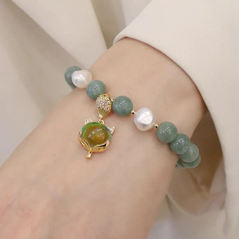 Burma jade warm fox pendant bracelet with temperature-sensitive feature and freshwater pearl accent on white background