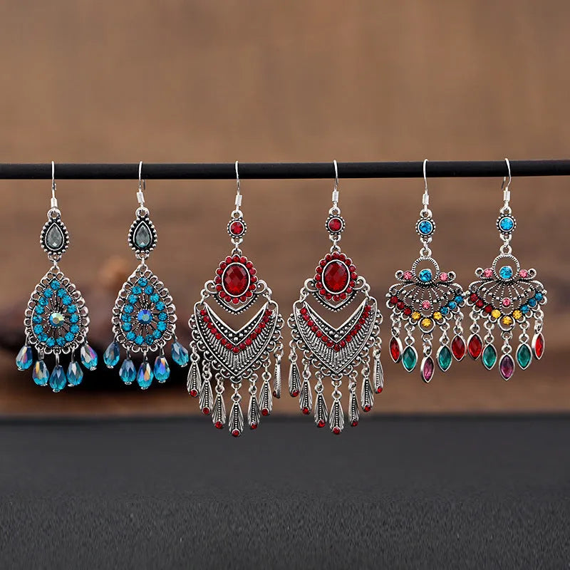 Purple drop-shaped earrings with long fringe detailing, showing retro ethnic style.