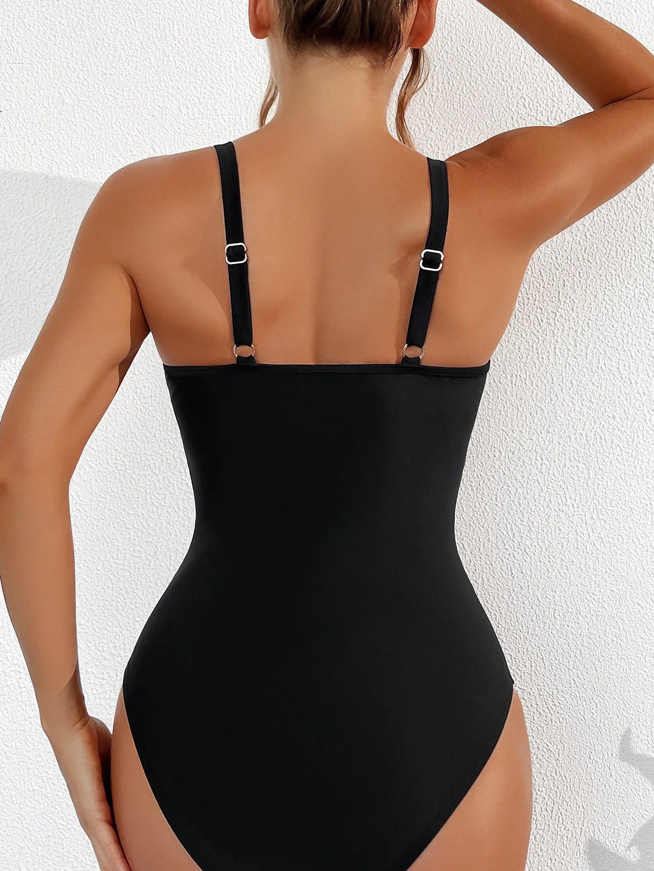 Black women's halter neck one-piece swimsuit with mesh detail and high-cut briefs.