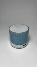 A9 Mini Cracked Bluetooth Speaker in blue with LED lights on a table