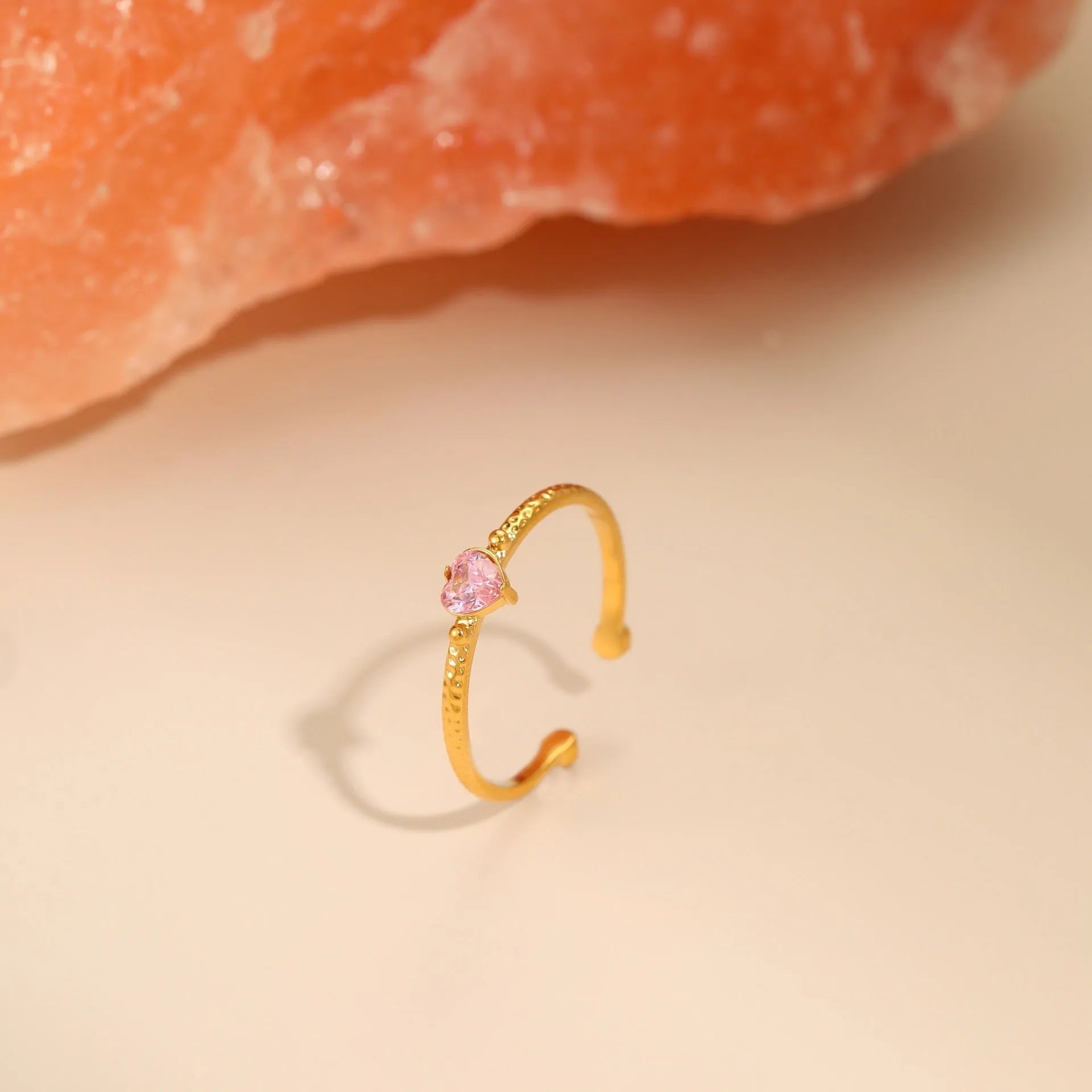 Open-ended stainless steel ring with a geometric heart shape and inlaid green zircon stone.