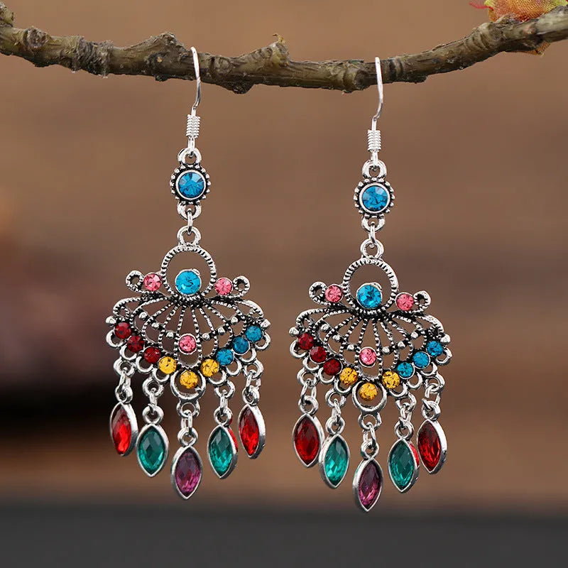 Purple drop-shaped earrings with long fringe detailing, showing retro ethnic style.