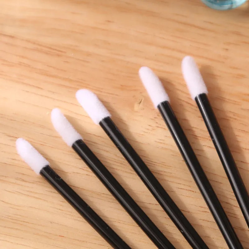 Pack of disposable lip brush applicators with coloured handles and flocked brush tips on a white background