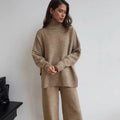 Women's knitted acrylic suit set with side-slit top and matching trousers in a solid colour.