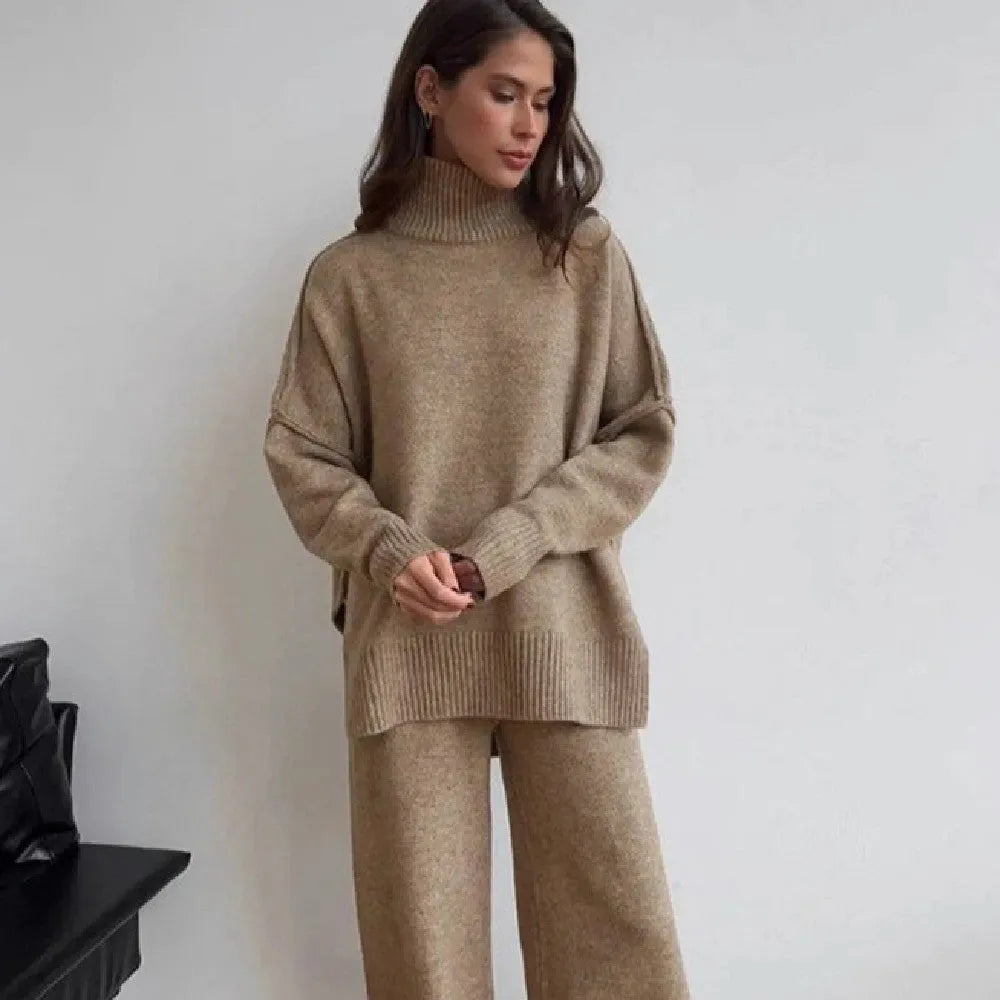 Women's knitted acrylic suit set with side-slit top and matching trousers in a solid colour.