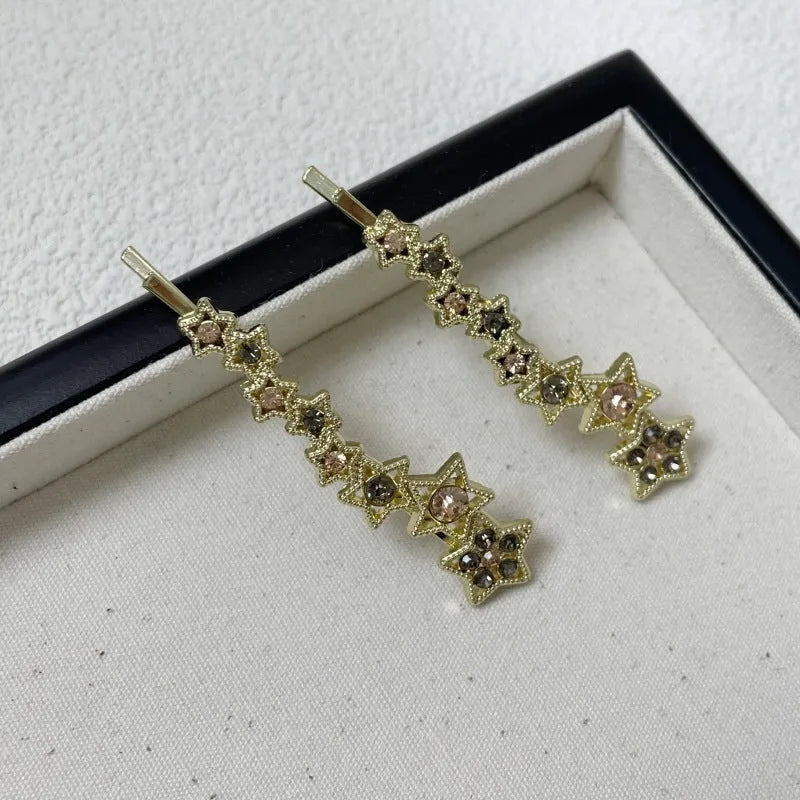 Gold-coloured alloy hair barrette with five-pointed star decoration and side-clip mechanism