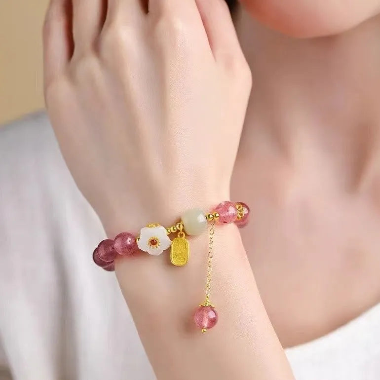 Handmade women's bracelet with strawberry quartz beads and Hetian jade peach blossom details.