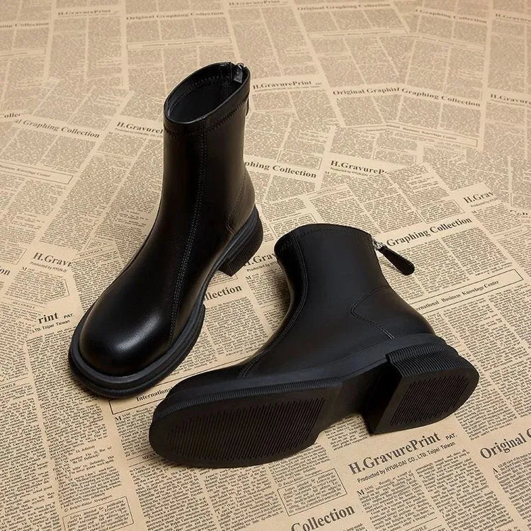 Women's black ankle boots with a flat thick heel, round toe, and a back zipper closure.