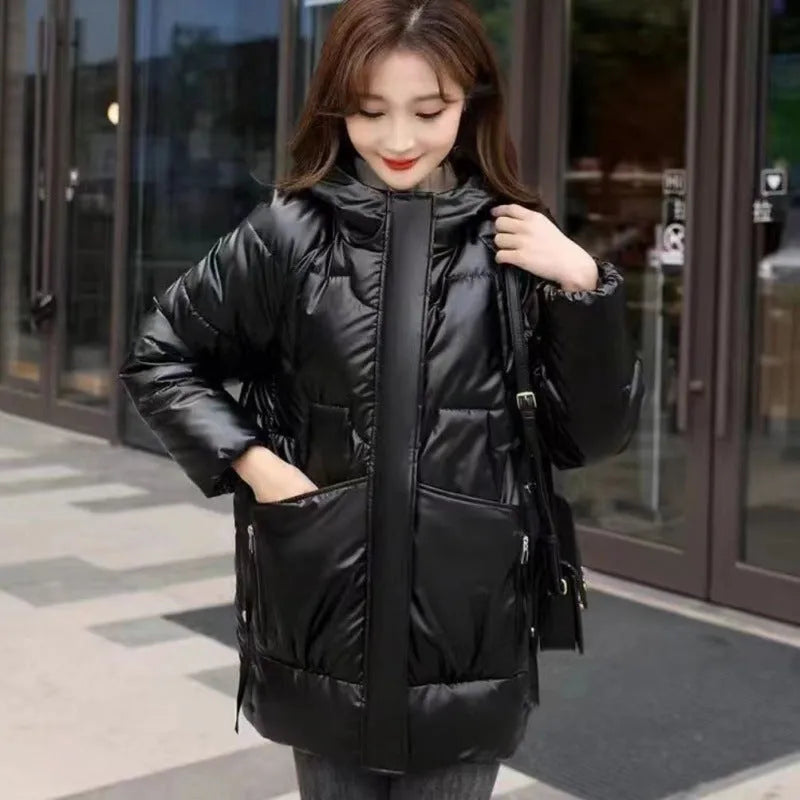 Woman wearing a loose-fit green hooded winter jacket with long sleeves.