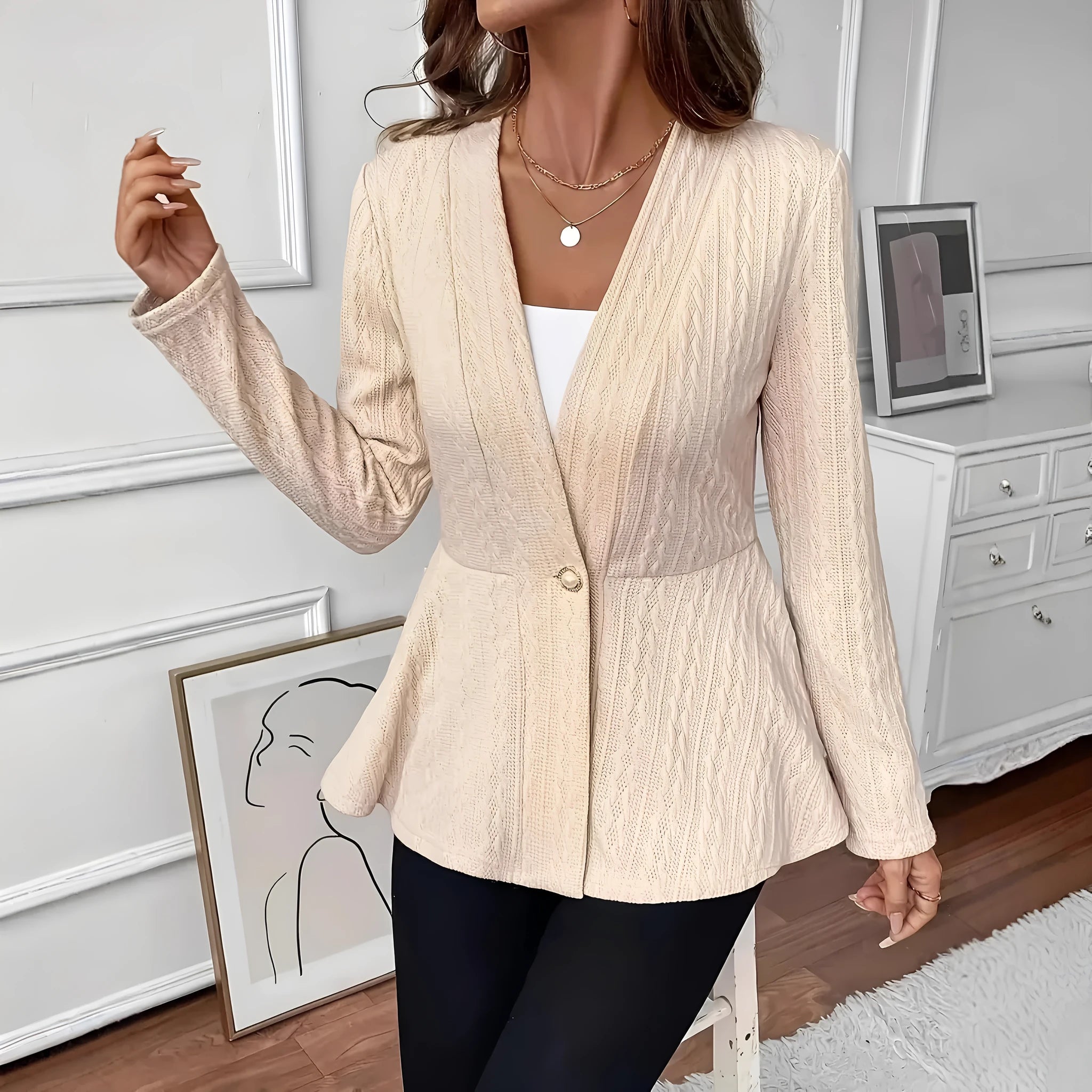 Women's apricot Jacquard knitted cardigan with a single button and long sleeves, laid flat.