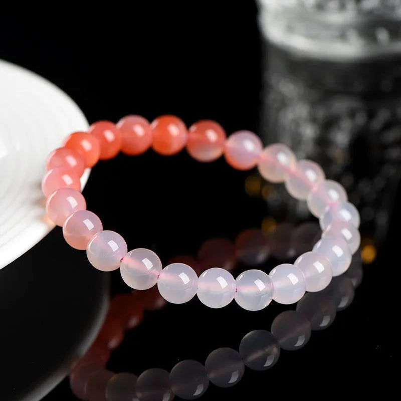 A gradient colour agate bead bracelet on a wrist, showing natural stone banding.