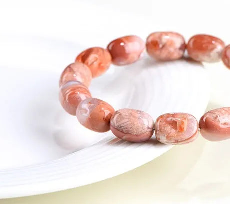 Natural cherry agate barrel bead bracelet with Ruyi decoration on white background
