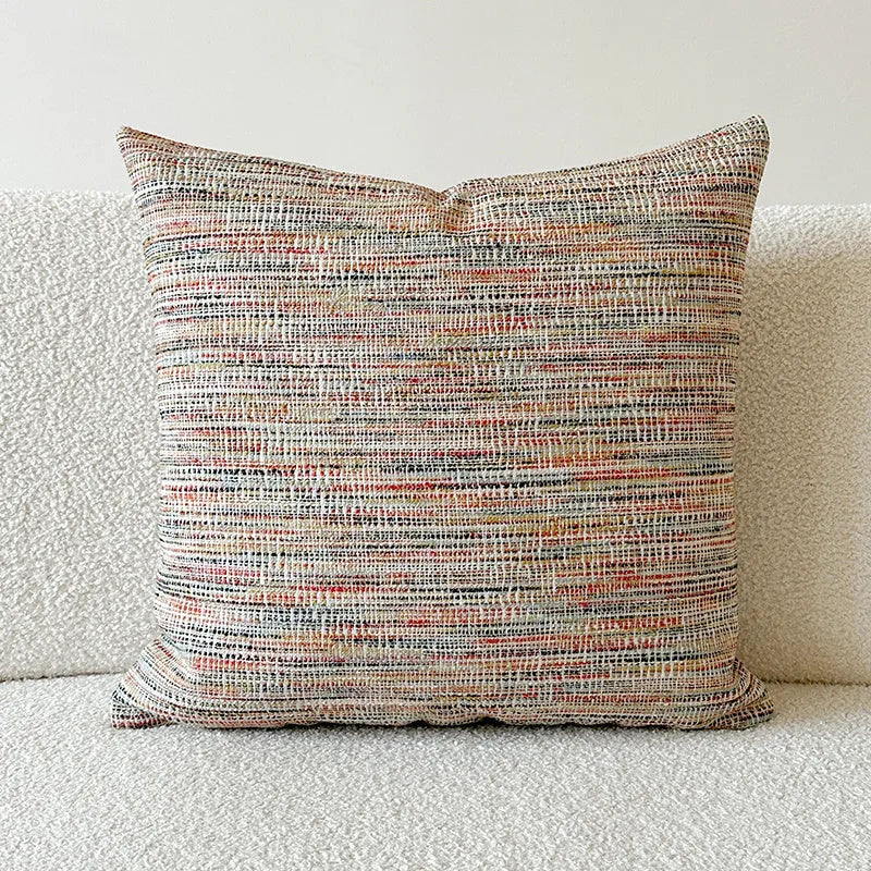 American-style jacquard pillow cover with paisley and flower pattern in amber colour, shown on a sofa.